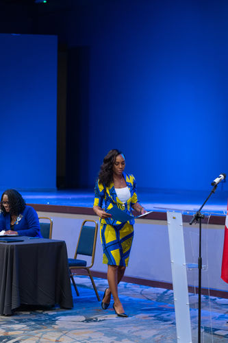 female delegate walking up to a podium at womens conference