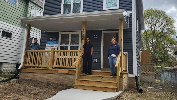 Homeowner and housing advocates on porch of new construction, Habitat for Humanity home in Milwaukee