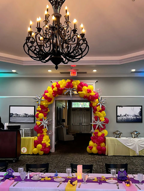 Hot pink and yellow graduation balloon arch with silver foil starbursts at The Vista at Van Patten Golf Club in Clifton Park NY.