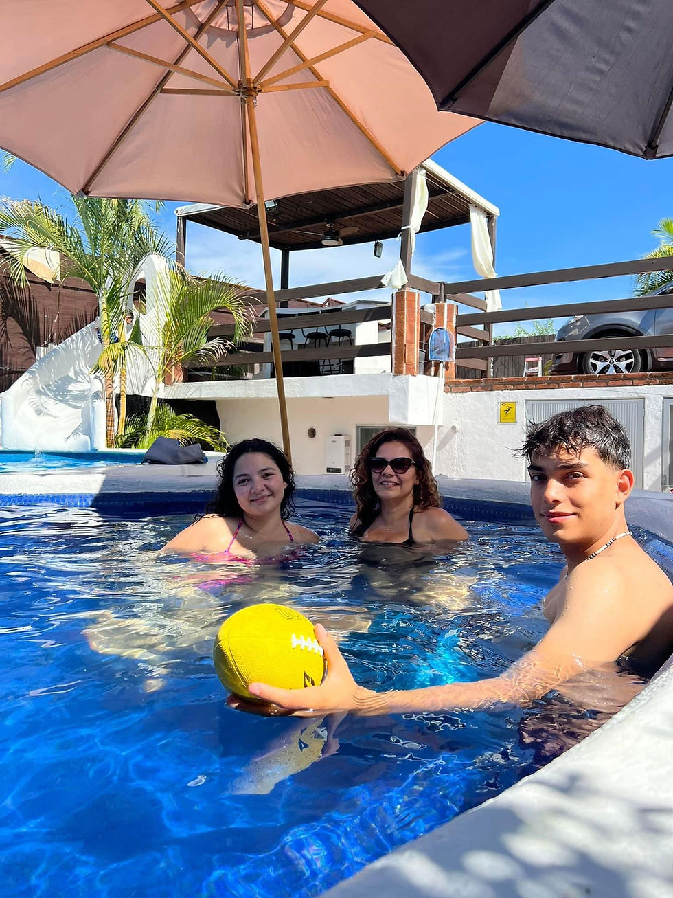 Familia y amigos disfrutando la alberca en Escondite Teques
