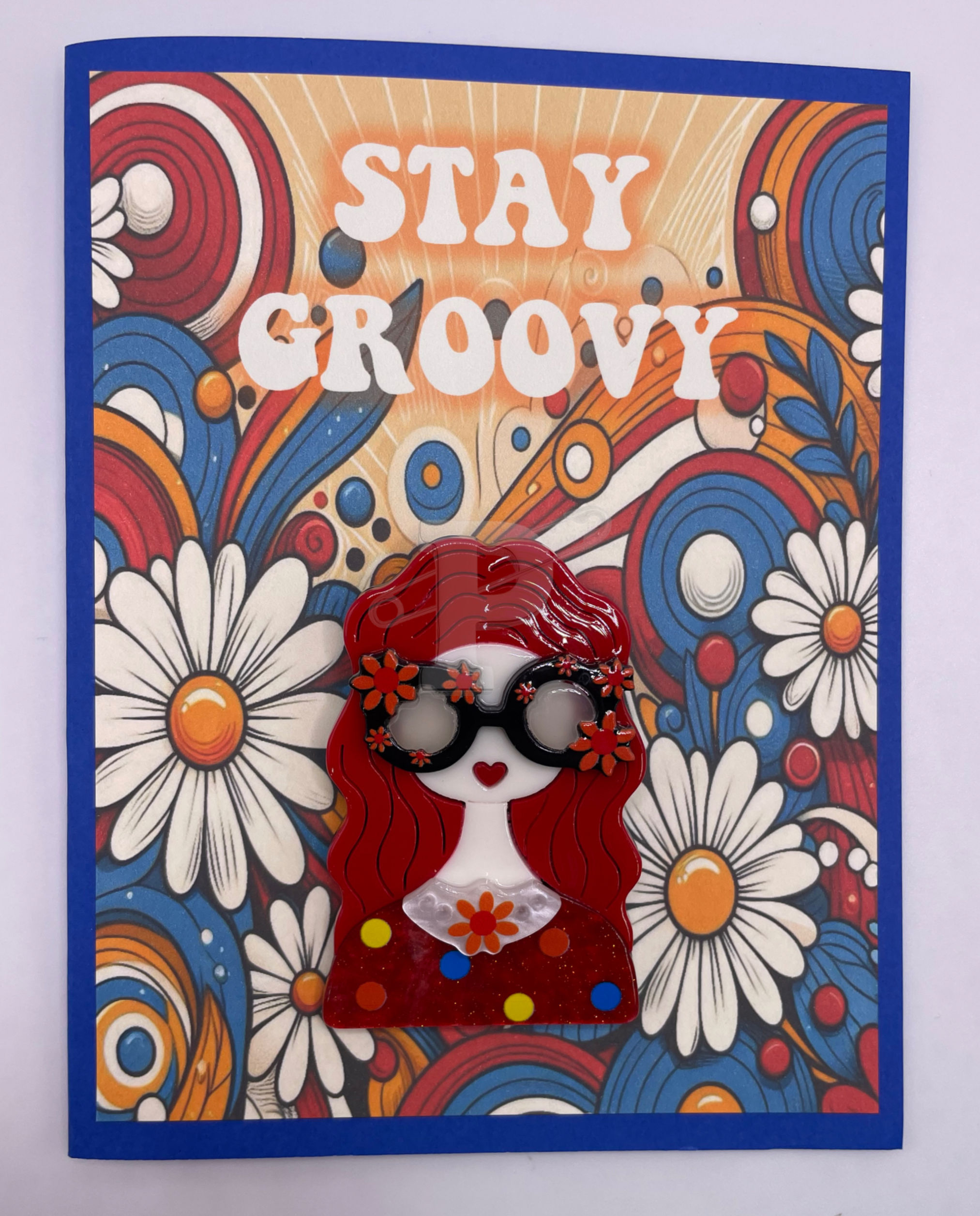 A greeting card that reads "Stay Groovy" with a flower-powered “Groovy Girl" brooch attached