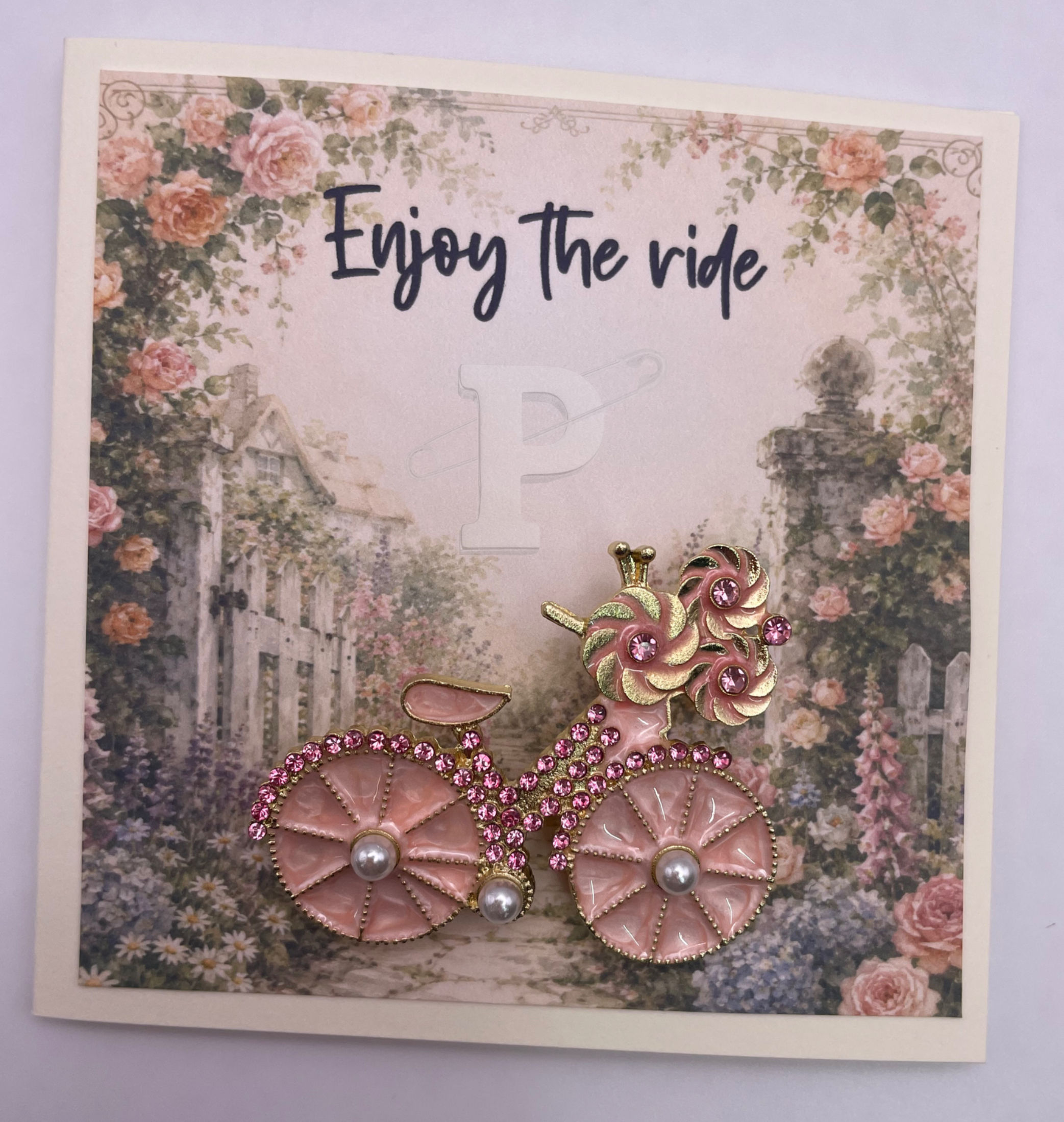 Pink vintage bicycle brooch with flowers on "Enjoy the Ride" inspirational card.