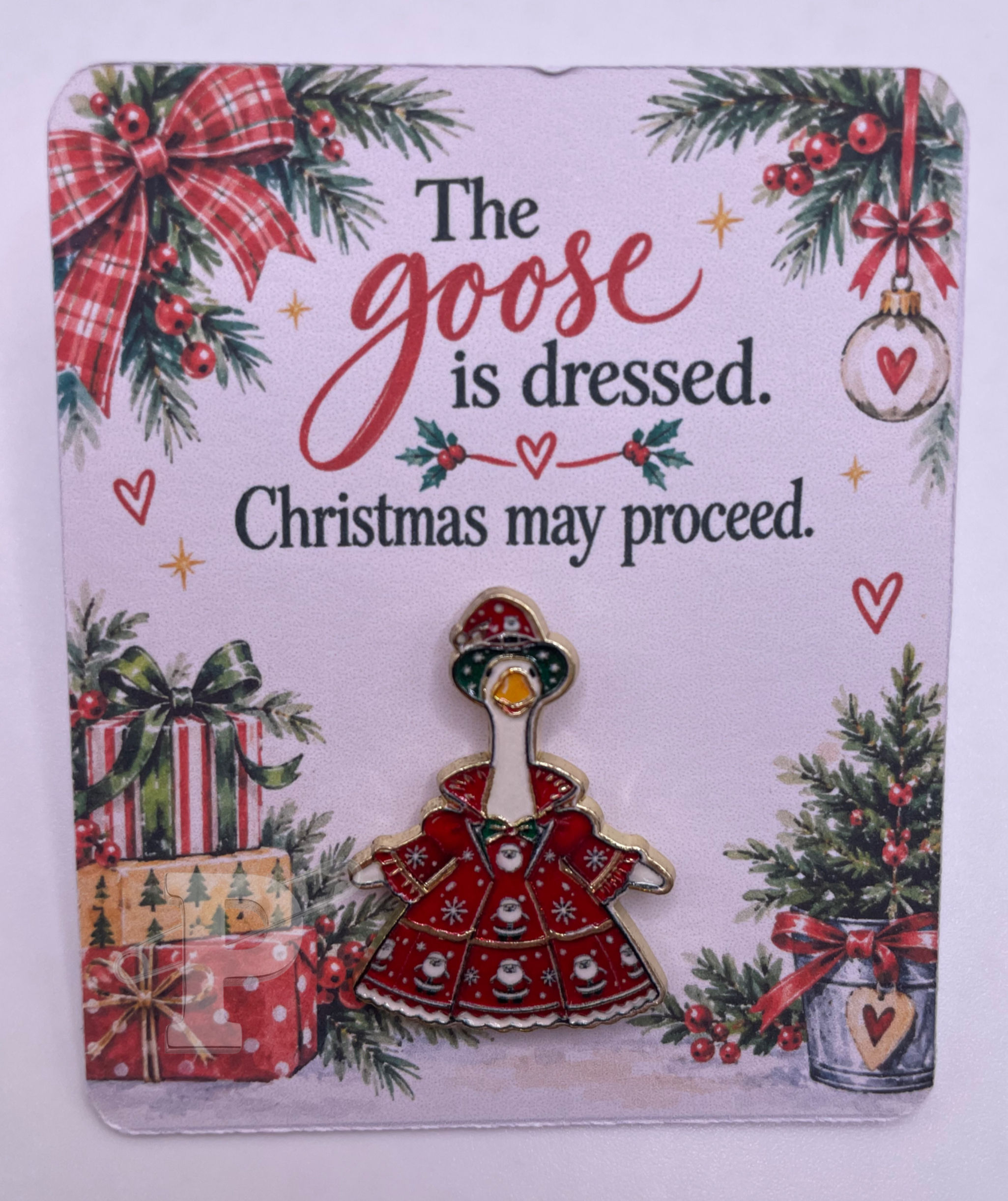 Christmas goose enamel pin on festive holiday card.