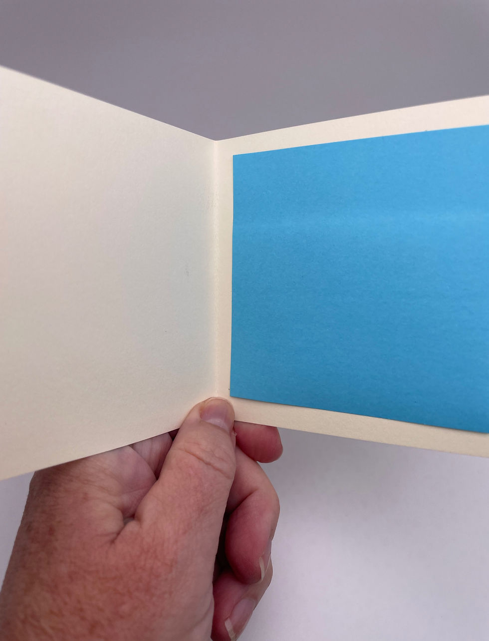 Blank cream-colored interior of the mini greeting card with a bright blue writing panel.