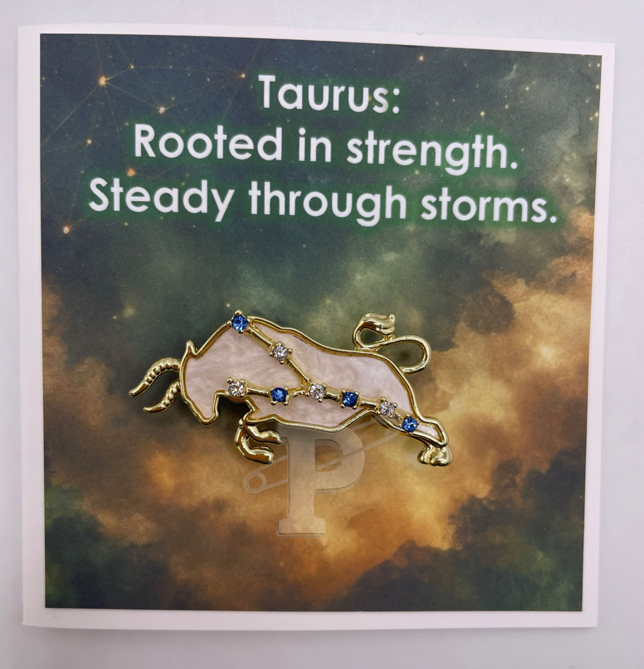 Mini card with text "Taurus: Rooted in strength. Steady through storms." with removable Taurus brooch attached.