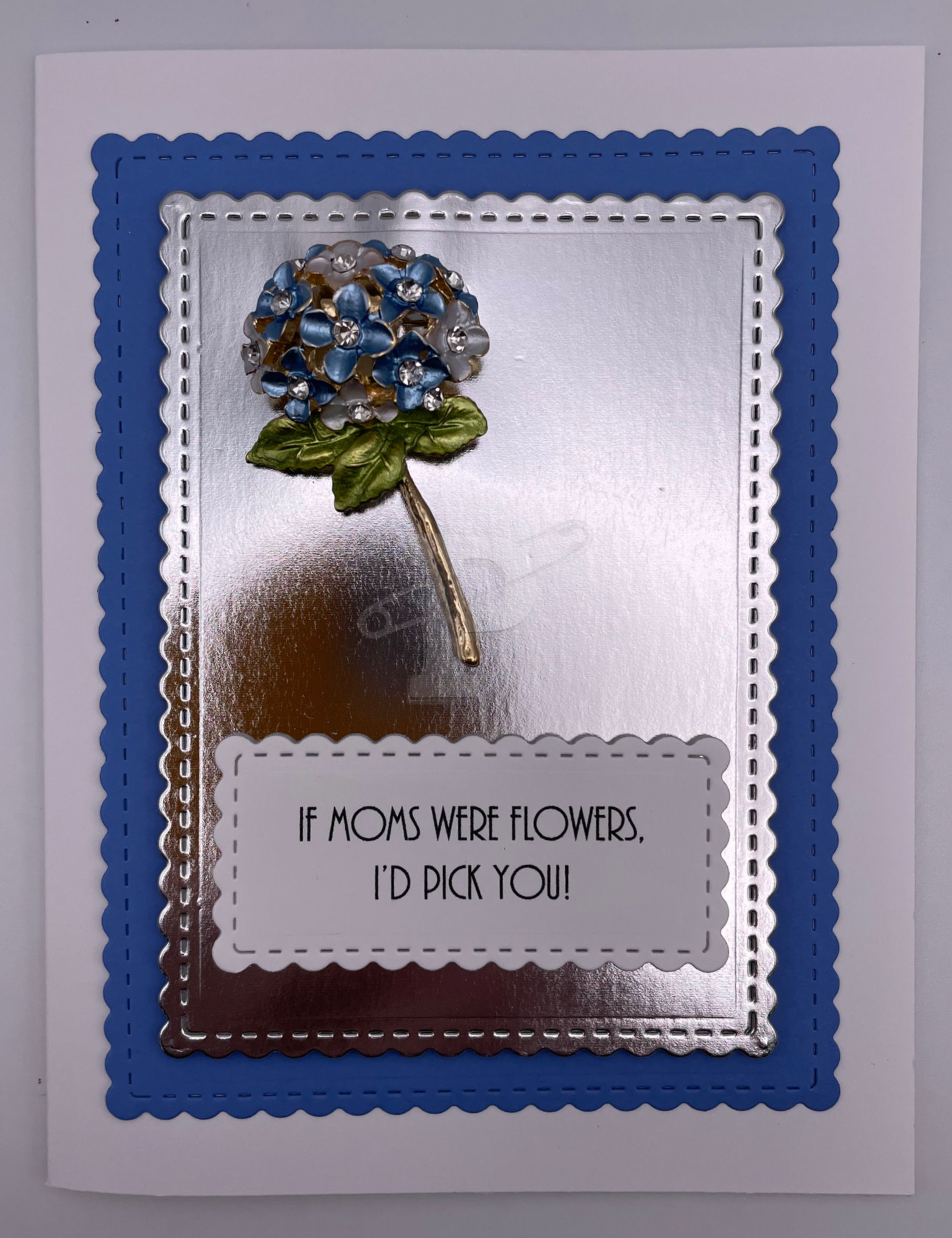 Blue hydrangea brooch with vibrant rhinestones, paired with sentiment "If moms were flowers, I'd pick you,"