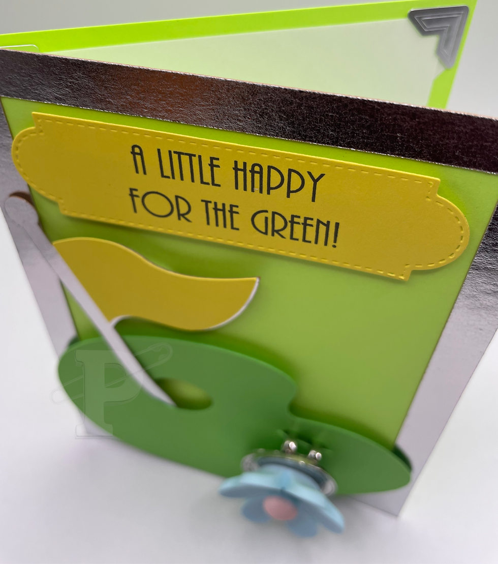 A golf-themed greeting card that reads"A little happy for the green" with flower golf ball marker and magnetic hat clip
