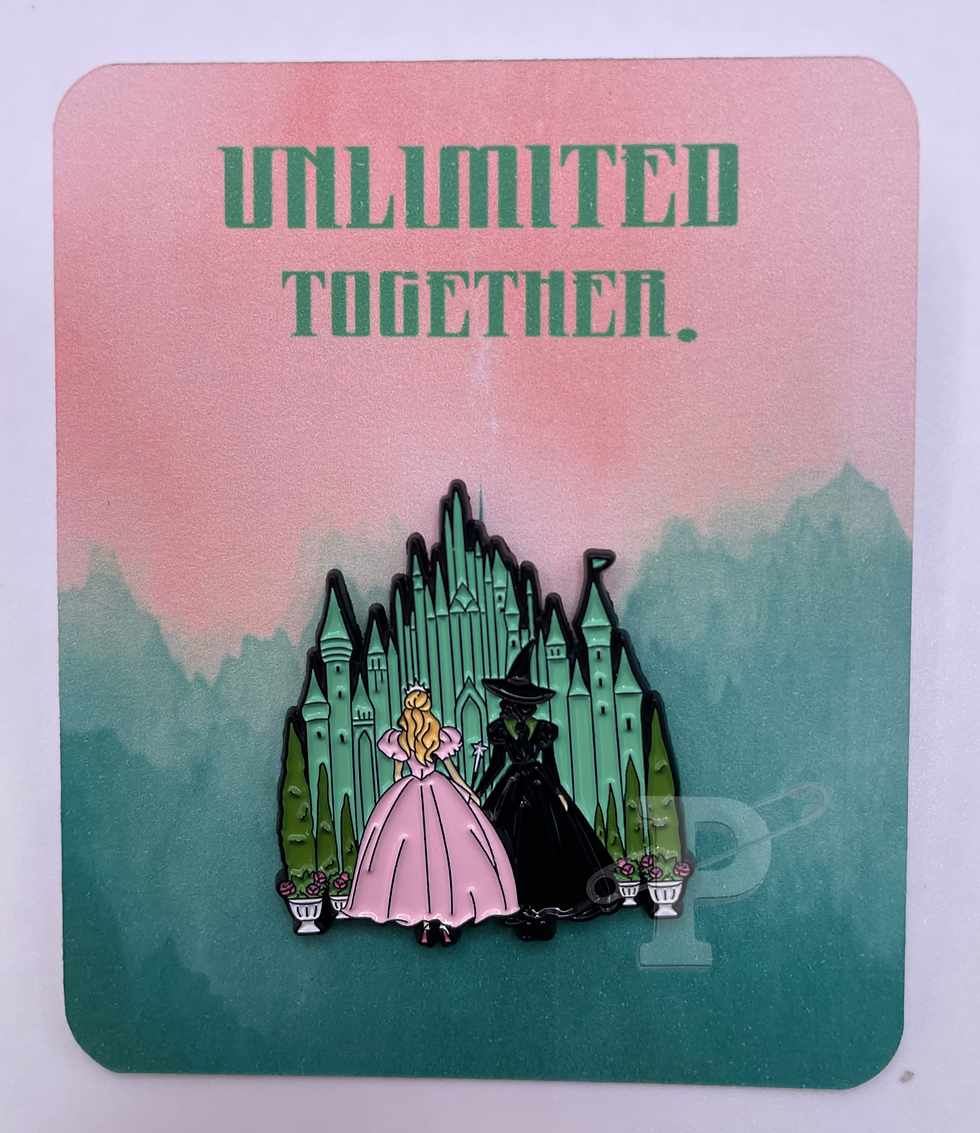 Flat card that reads “Unlimited Together” with a pin showing two witches—one in pink, one in black—standing before a green ca