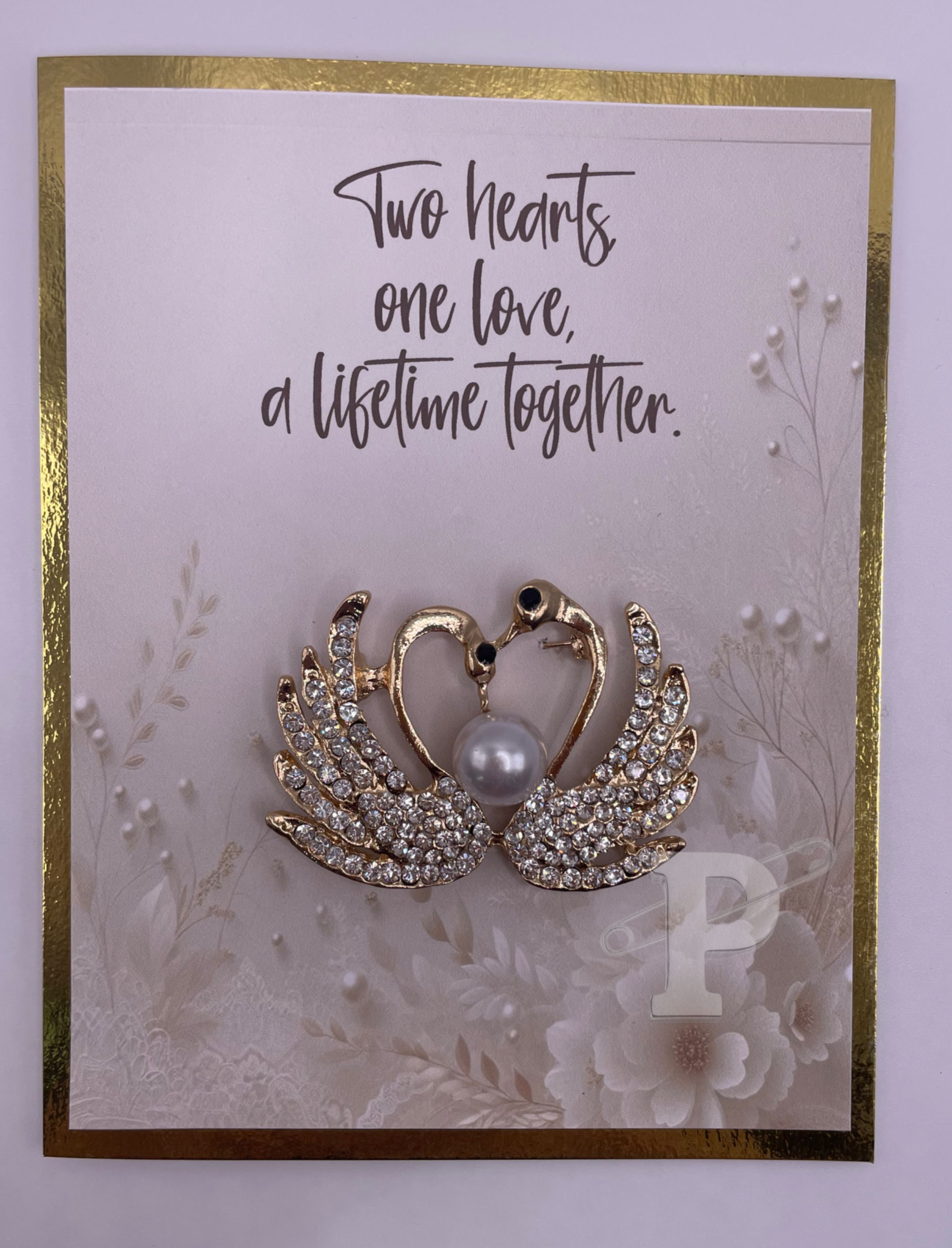 Greeting card with swan brooch forming a heart, pearl center, and sparkling wings, with text “Two hearts, one love, a lifetim
