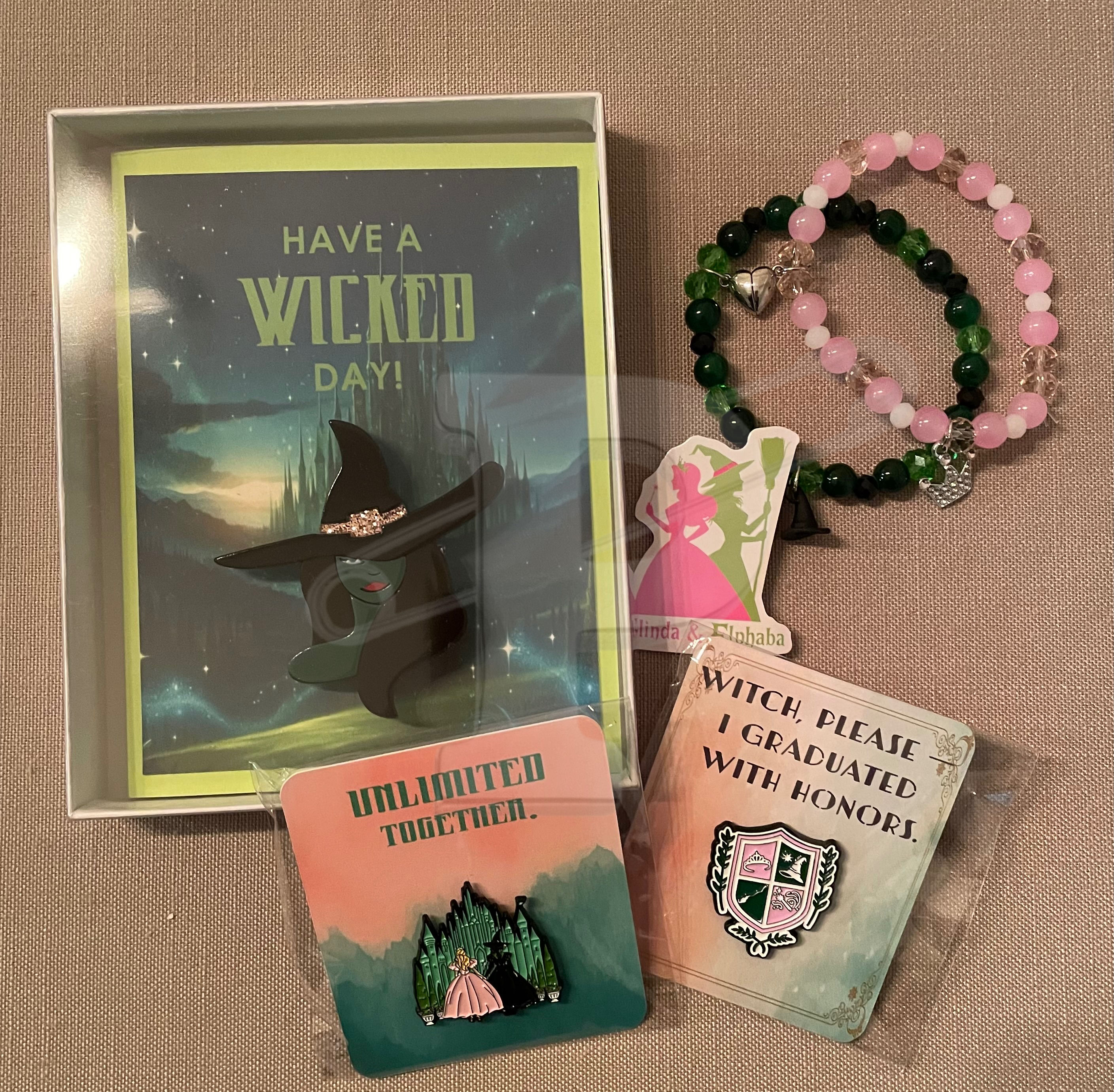 Wicked-themed bundle with a ‘Have a Wicked Day’ brooch card, two pins, a two-piece bracelet and sticker