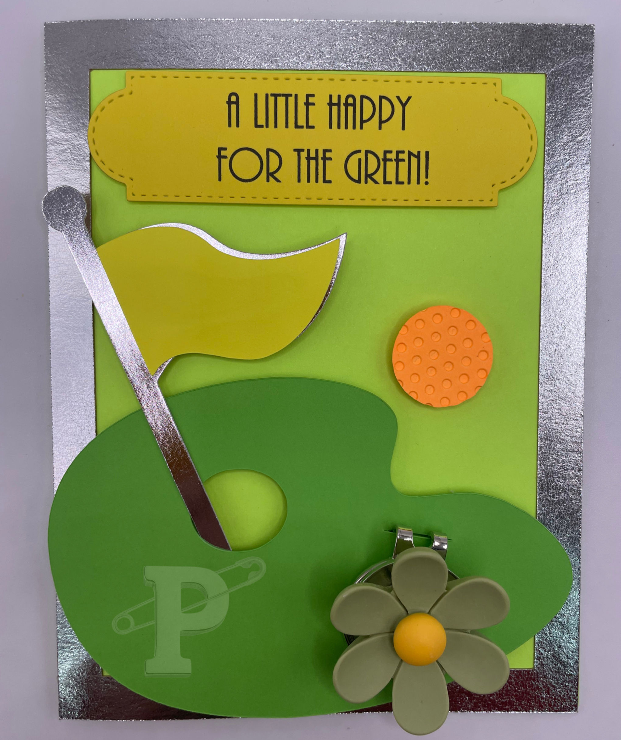 Greeting card that reads"A little happy for the green" with flower golf ball marker and magnetic hat clip