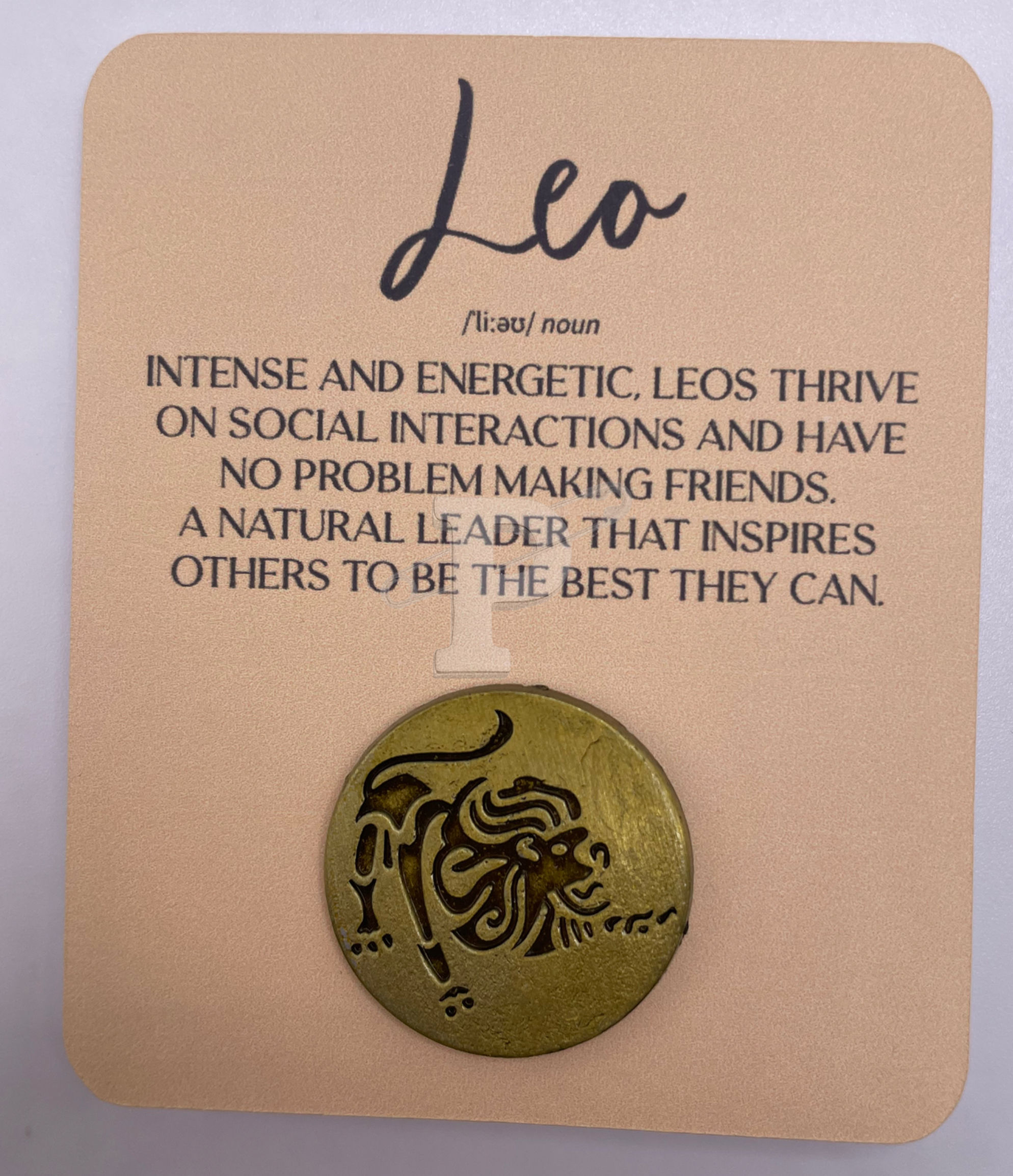 A flat card with Leo definition with Leo pin attached.