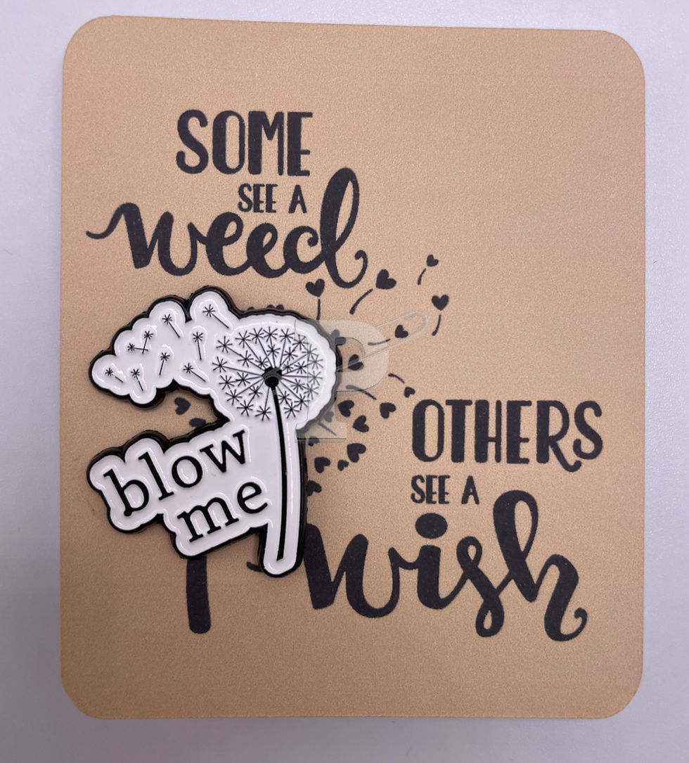 A flat card with attached enamel pin with dandelion that says "Blow me"