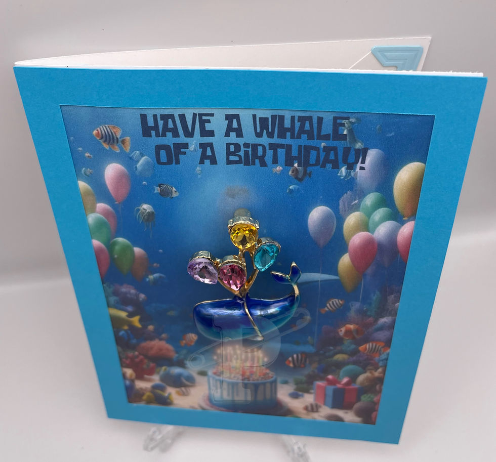 Handcrafted birthday card with detachable blue whale brooch, featuring colorful balloons and an underwater celebration theme.
