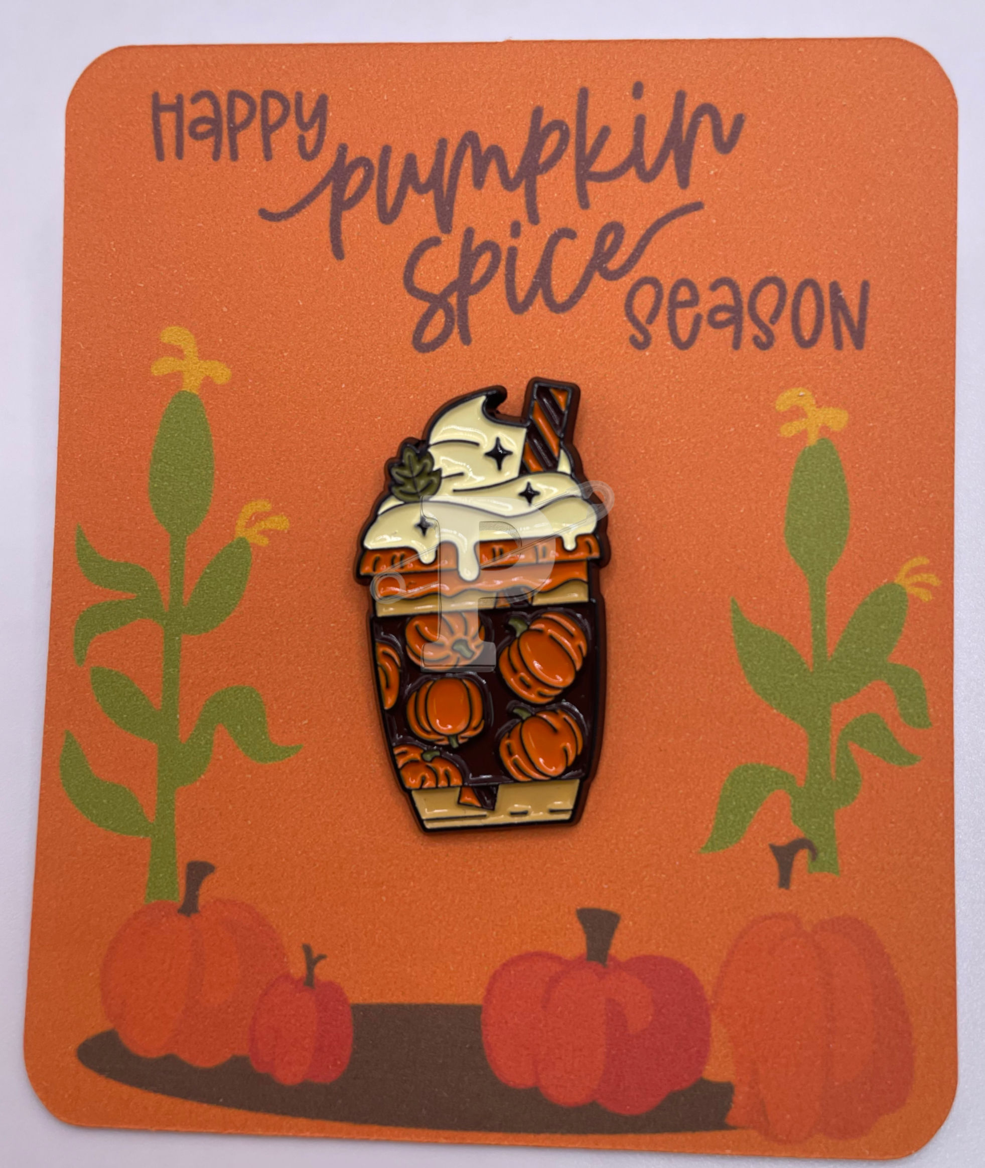 A flat card that reads Happy Pumpkin Spice Season with a pins shaped like a coffee cup decorated with a pumpkins
