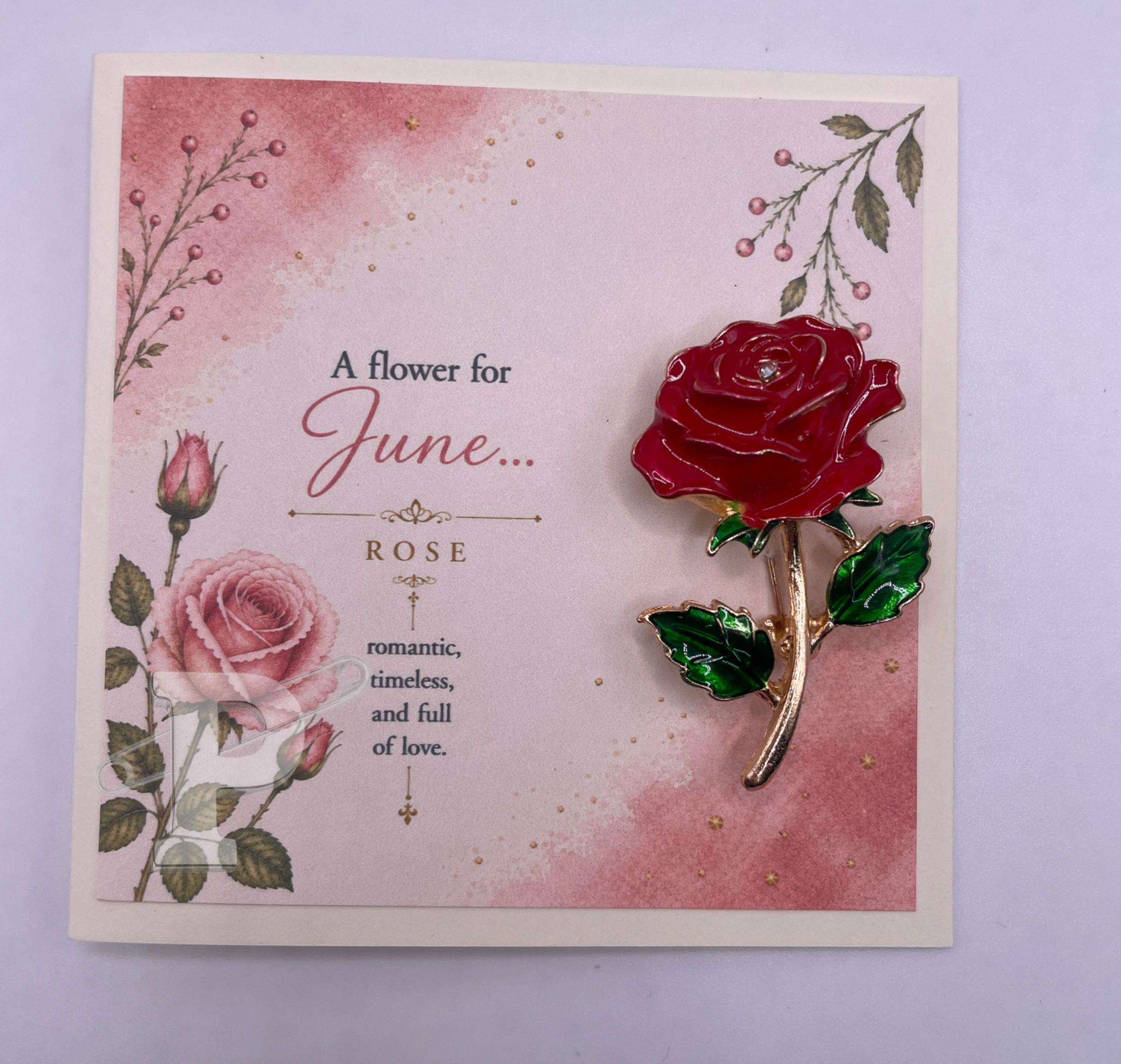 June birth month flower card featuring a red rose brooch and watercolor rose artwork.