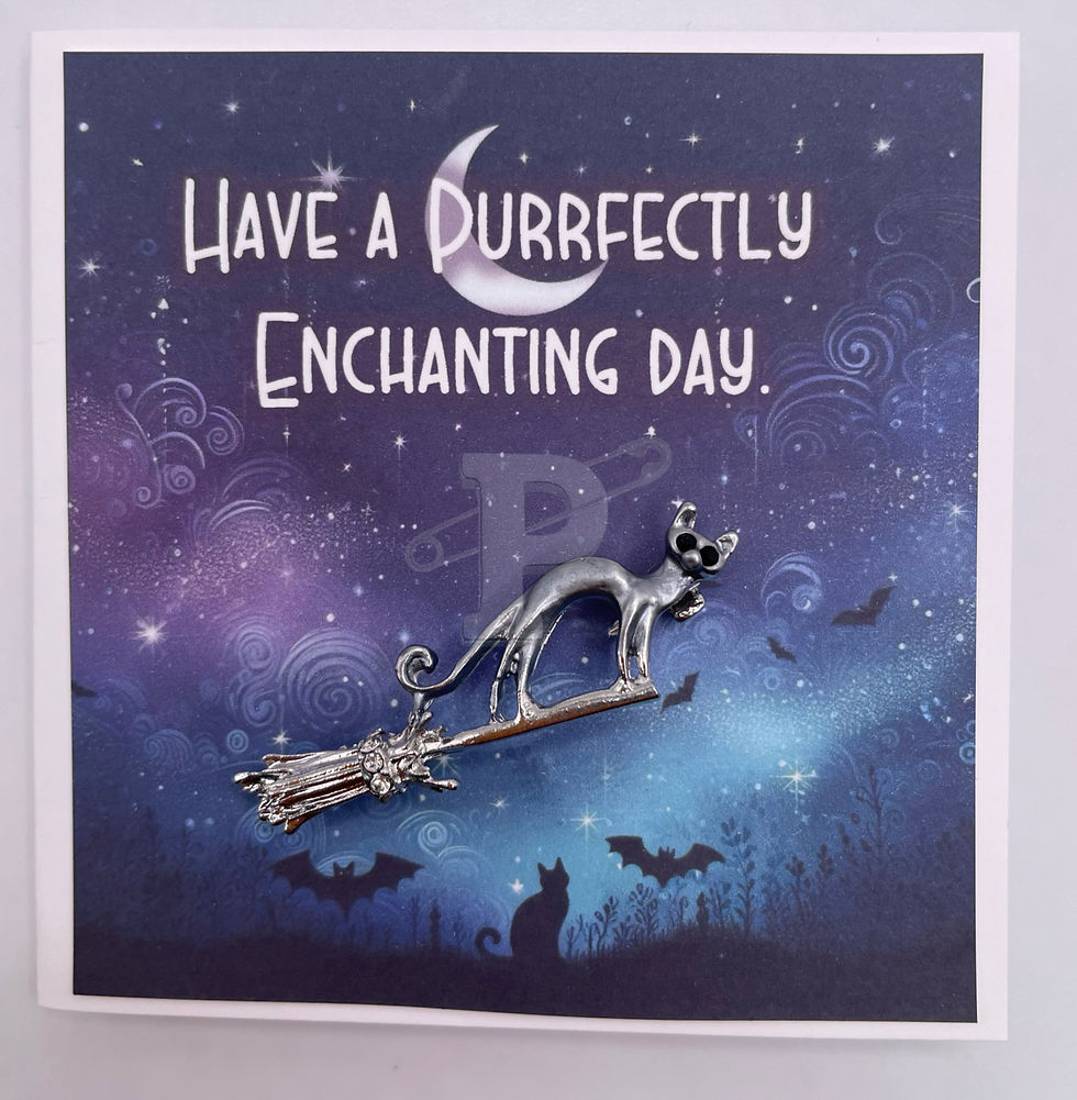 A mini greeting card that reads "Have a purrrfectly enchanting day" with a cat on a broom brooch attached