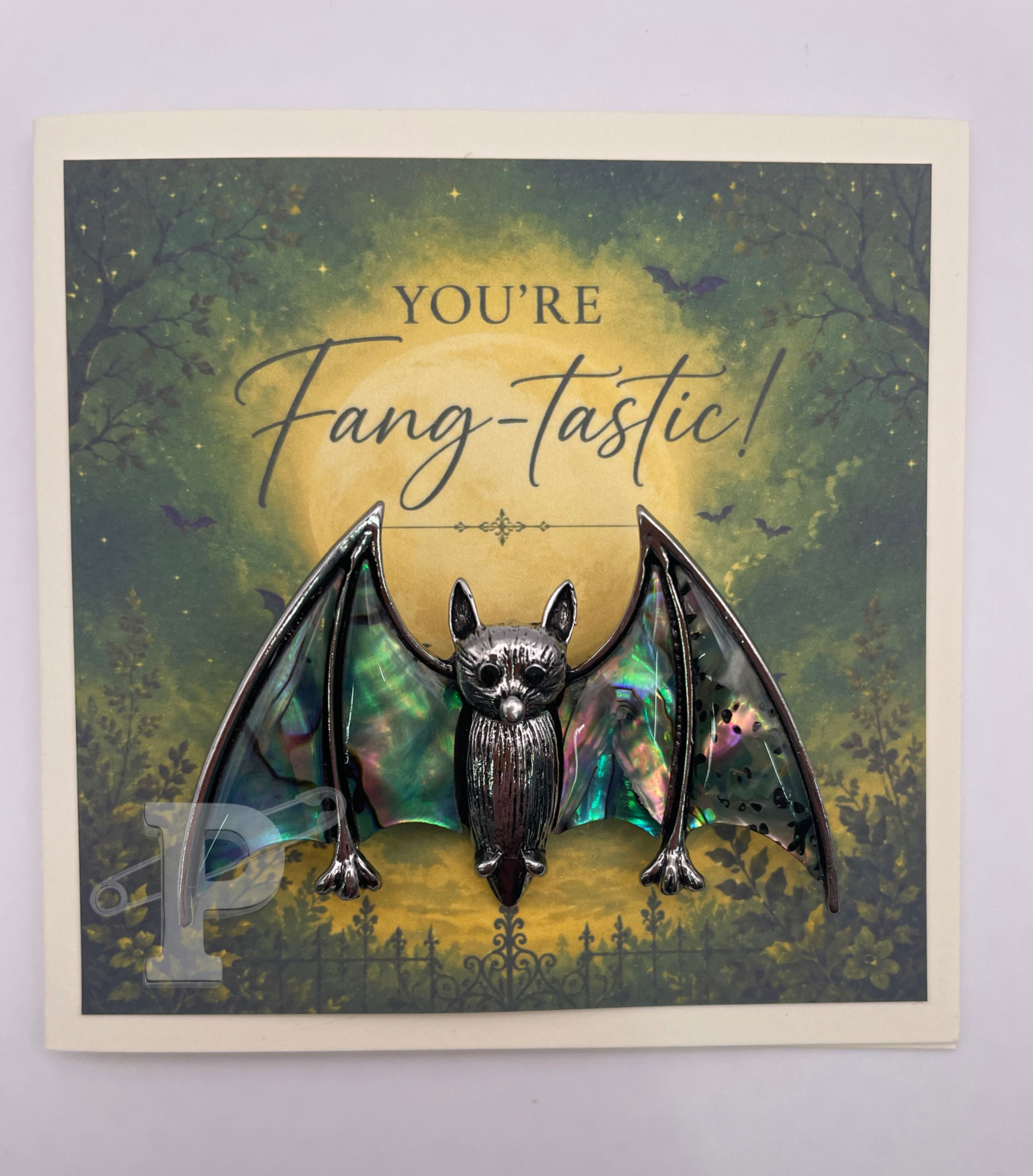 Mini greeting card with a removable iridescent bat brooch featuring the sentiment, "You're Fang-Tastic!"