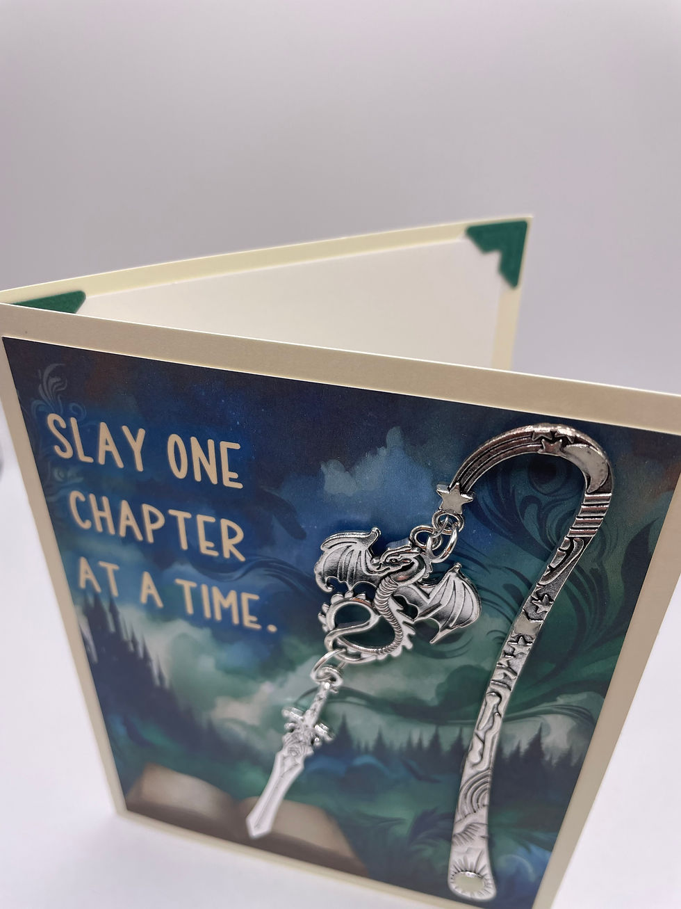 Thumbnail: Top view of dragon and sword bookmark on a fantasy background  that reads “Slay one chapter at a time.” Handle glows in dark
