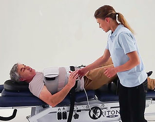 Patient receiving non-surgical spinal decompression on a Chattanooga Triton DTS table at Triangle Spinal Decompression in Cary, NC.