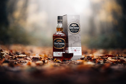 Photographie publicitaire de bouteille de whisky réalisée en lumière naturelle par un photographe produit professionnel à Paris
