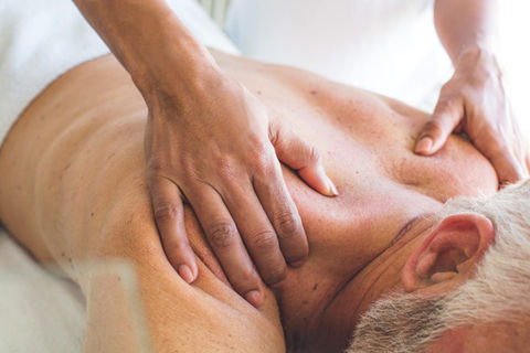 A senior man getting a massage at home