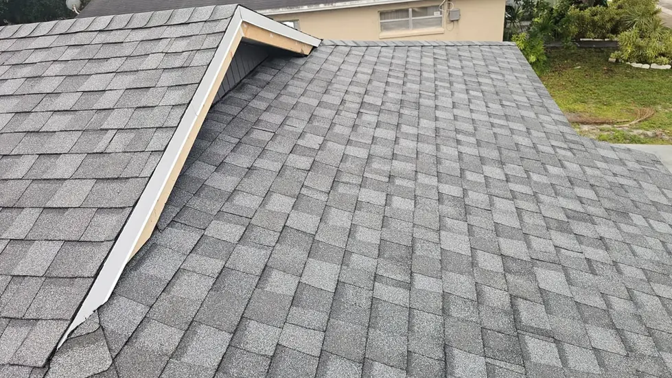 Newly installed gray shingle roof with finished valley flashing and clean roof transitions