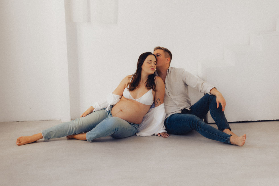 a man kisses a pregnant woman on the cheek