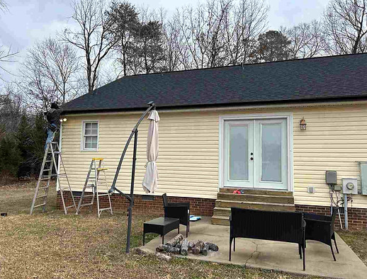 Seamless gutters Garner NC installation in Bainbridge, Garner NC 27529 featuring new black 5-inch seamless gutters replacing the old worn white gutters to improve drainage and update the exterior appearance of the home.