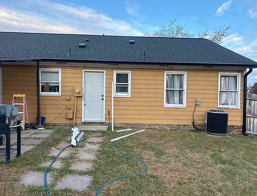 Gutters Wendell North Carolina project in Greystone, Wendell NC 27591. Rear exterior after photo showing new black 5-inch seamless gutters replacing old worn white gutters to improve rainwater drainage and update the appearance of the home.