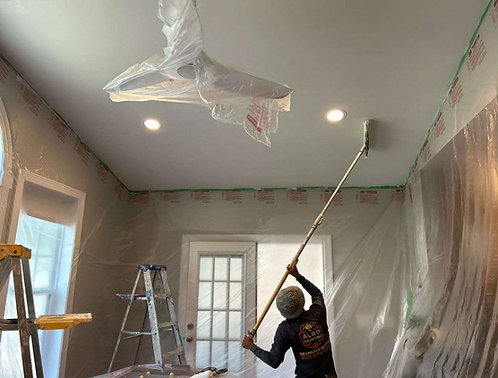 painter uses a roller to apply new white paint to the ceiling of the sunroom in Briar Chapel, Chapel Hill