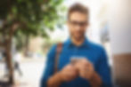 Professional man outside looking down at his mobile phone