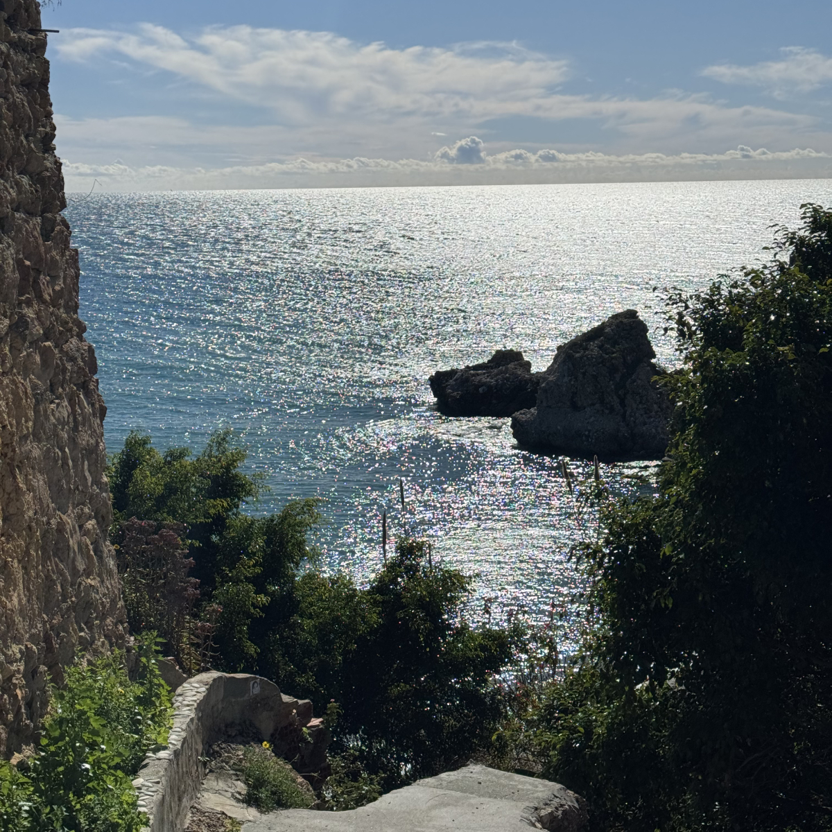 Nerja tidig vår från trappan vid Parador innan Burrianastranden. Härlig grönska och medelhavet med solens strålar som gör att vattnet glittrar.