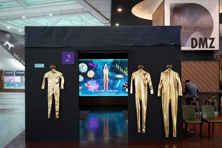 Unfolding, a short experimental film set in 2070, features a wellness session where nature takes the role of an off-screen narrator guiding a futuristic figure. This video art piece critiques the wellness industry and challenges the hierarchical relationship between humans and the environment. Through contemporary art, Unfolding offers an imaginative reflection on humanity's reliance on nature, positioning the natural world as an active participant.