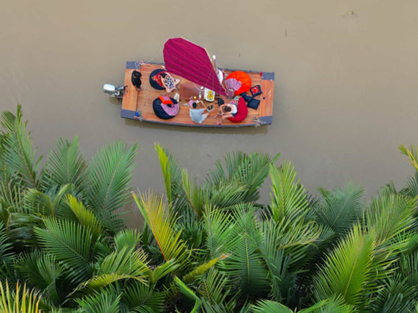 Aerial view of tourists relaxing on beanbags during Mekong River cruise in Ben Tre