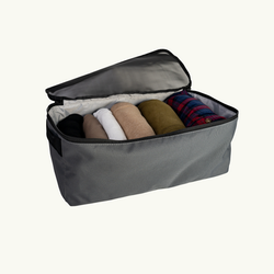 Gray fabric storage cube with rolled-up clothes