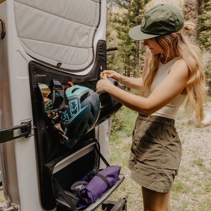 Woman organizing gear in van door storage
