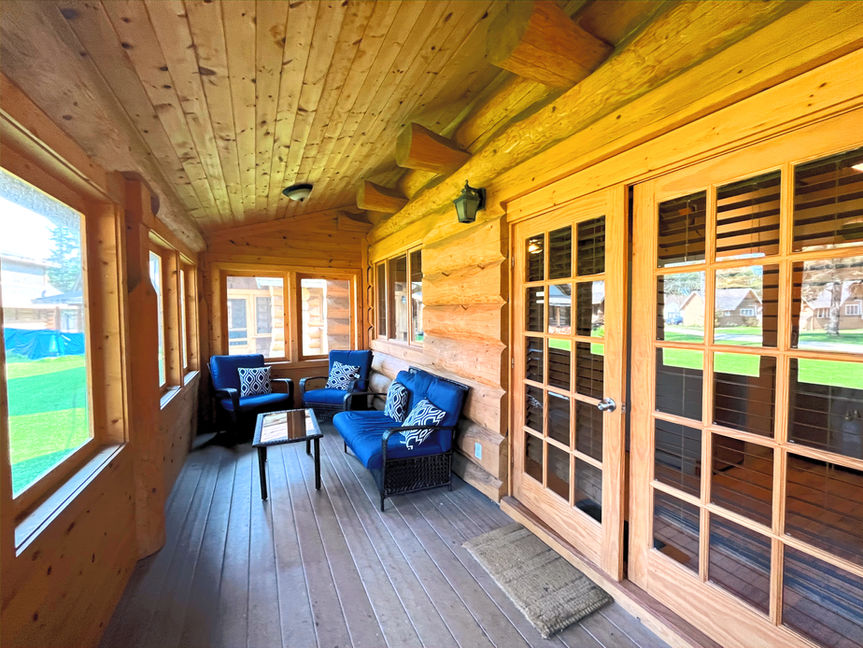 An enclosed wooden porch with seating 