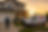 Supra Exterminator technician arriving at a modern suburban home at sunset, with branded service van and family waving from porch