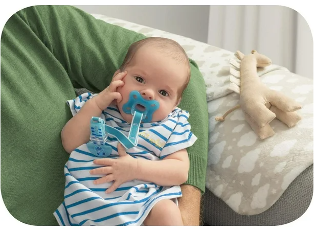 Thumbnail: Baby with blue pacifier held by person, MAM Comfort Pacifier, 0-3 Months.