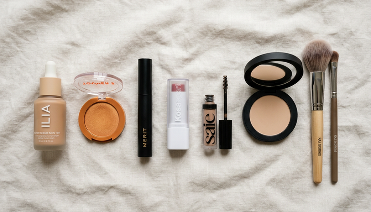 Flat-lay view of everyday cosmetics on a soft neutral surface