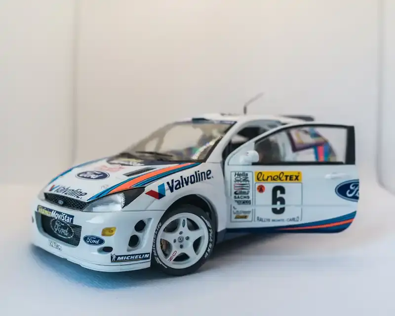 White Ford Focus RS WRC rally car model with Valvoline branding and number 6. The door is open, showing interior details. Racing decals are visible.