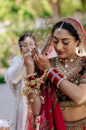 Bride taking part in the Sikh wedding rice-throwing tradition, tossing rice toward her family during an emotional and meaningful wedding ceremony in Barbados.