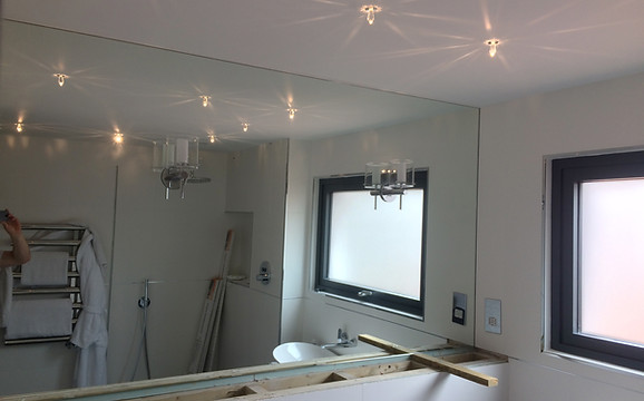 Large square mirror behind sink area in bathroom