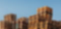 Stacked up colourful wooden cargo pallets against a blue sky