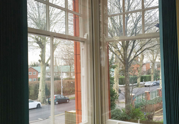 Secondary glazing in home windows covered by green blinds