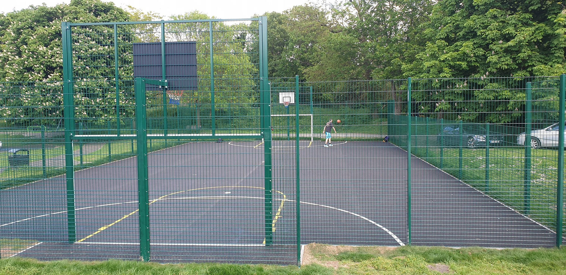 Looking through a metal fence at a sports area