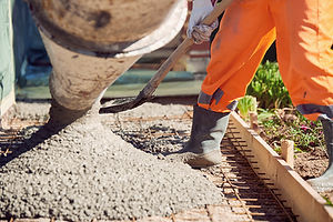 Worker with gum boots spreading ready mix concrete.jpg