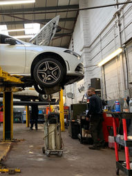 White car on a 2 post lift