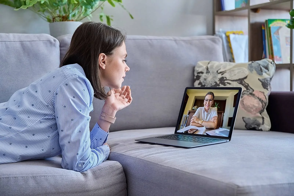 Woman attending an online therapy session on her laptop, receiving mental health support from a professional therapist.